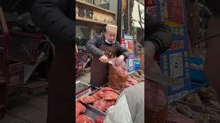 The beef seller is cutting the cooked beef with a knife