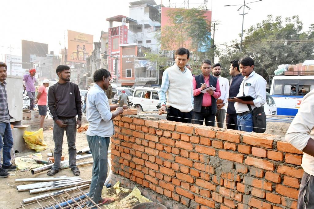 महाकुंभ 2025 के दृष्टिगत प्रयागराज विकास प्राधिकरण द्वारा कराए जा रहे विभिन्न कार्यों में से मजार चौराहे, तेलियरगंज चौराहे एवं महिला ग्राम चौराहे (चौफटका) पर कराए जा रहे चौड़ीकरण एवं सौंदर्यीकरण के कार्यों का निरीक्षण आज मंडलायुक्त श्री विजय विश्वास पंत ने सभी संबंधित अधिकारियों की उपस्थिति में किया। उन्होंने सर्वप्रथम मजार चौराहे पर कराए जा रहे दोनों रोटरी के कार्यों की प्रगति समीक्षा की जिसके अंतर्गत कॉन्ट्रैक्ट की सीमा पूरी हो जाने के पश्चात् भी कार्यों की प्रगति धीमी पाई गई।
तेलियरगंज चौराहे के निरीक्षण के दौरान भी कॉन्ट्रैक्ट की सीमा पूरी हो जाने के पश्चात् भी कार्यों की प्रगति धीमी पाई गई। मण्डलायुक्त ने कार्यों में शिथिलता बरतने तथा कॉन्ट्रैक्ट की सीमा पूरी हो जाने के पश्चात् भी कार्यों की प्रगति धीमी होने पर सम्बंधित अधिकारी को ठेकेदार के विरुद्ध कड़ी कार्रवाई करते हुए हैवी पेनाल्टी लगाने (लिक्यूडेशन डैमेज लेने) तथा दोनों चौराहों के अवर अभियंता एवं सहायक अभियंता को एडवर्स एंट्री देने के निर्देश दिए।
इसी क्रम में उन्होंने महिला ग्राम चौराहे (चौफटका) पर कराए जा रहे कार्यों का भी निरीक्षण किया। उक्त चौराहे के कई साइटों पर एक साथ कार्य होना था जिसके दृष्टिगत ठेकेदार को लेबरों की संख्या बढाते हुए कार्यों में प्रगति लाने के निर्देश दिए गए थे। परन्तु निरीक्षण के दौरान लेबरों की संख्या अपेक्षा से कम पाई गई। मण्डलायुक्त ने कॉन्ट्रैक्ट की सीमा पूरी हो जाने के पश्चात् भी कार्यों की प्रगति धीमी होने पर सम्बंधित अधिकारी को ठेकेदार के विरुद्ध कड़ी कार्रवाई करते हुए हैवी पेनाल्टी लगाने (लिक्यूडेशन डैमेज लेने), दोनों चौराहों के अवर अभियंता एवं सहायक अभियंता को एडवर्स एंट्री देने तथा कार्यों में शिथिलता बरतने पर ठेकेदार को डीबार करने पर विचार करने के निर्देश दिए।